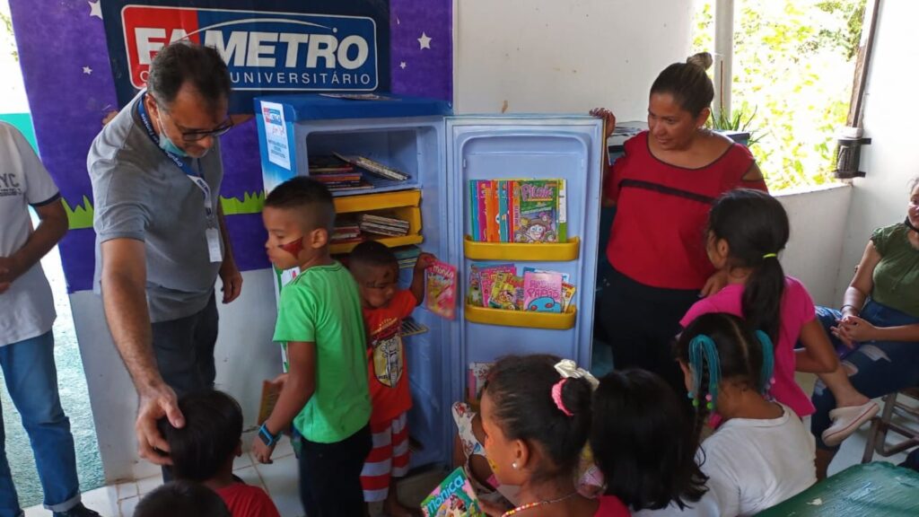 Imagem mostra a inauguração da geladeira-biblioteca na escola municipal