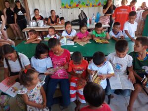 Imagem mostra alunos da escola onde foi inaugurada a geladeira-biblioteca