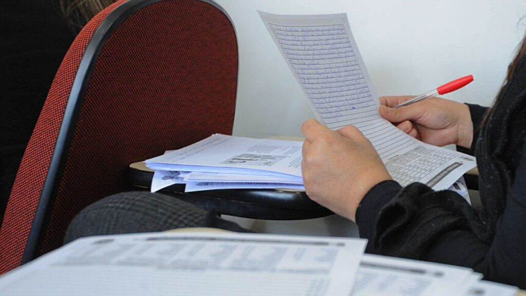 Imagem mostra uma redação segurada por um estudante e que será trabalhada em oficinas no projeto Minha Redação é Nota 10